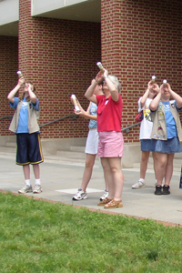 Girls and adults look at the sky with their spectroscopes