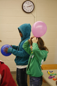 Girls hold balloons representing different sizes of stars