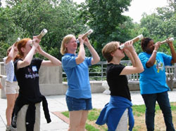Picture of girls and leader looking through spectroscopes made from papertowel tubes, as described in the activities section of this web site