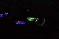 The paths of glow stick necklaces are shown when room lights are off
