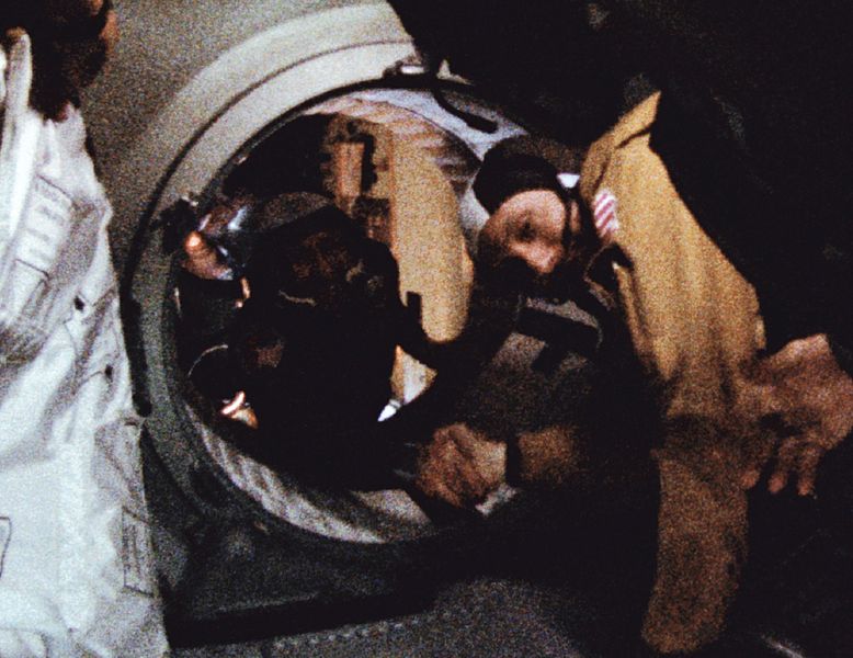 Apollo astronaut and Soyuz cosmonaut shake hands in space