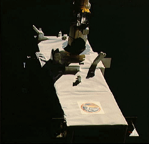 Photo of the Spartan 1 satellite being deployed by the Space Shuttle Discovery's manipulator arm.