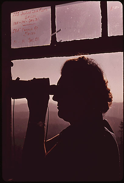Photo of a woman looking through a telescope